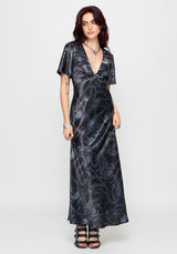 Woman wearing a black maxi satin snake printed dress on a white background