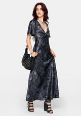 Woman wearing a black maxi satin snake printed dress on a white background