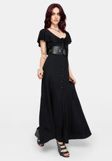 Woman wearing a black maxi dress with a high slit and ruffle sleeves on a white background