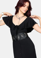 Woman wearing a black maxi dress with ruffle sleeves and a black waist belt on a white background