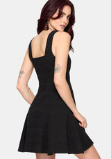 Woman wearing a black dress against a white background