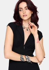 Woman wearing a black dress with silver jewelry on a white background