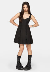 Woman wearing a black dress with lace details on a white background