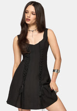 Woman wearing a black mini dress with lace details on a white background
