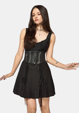 Woman wearing a black dress with corset belt on a white background