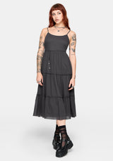 Woman wearing a grey tiered midi dress on a white background