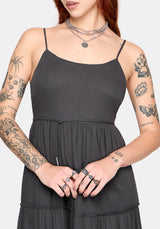 Woman wearing a charcoal dress with silver jewellery on a white background