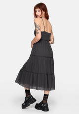 Woman wearing a grey dress with a sheer overlay on a white background