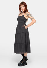 Woman wearing a grey dress with tiered layers on a white background