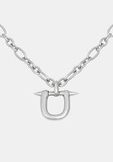 A silver-toned metal necklace featuring a U-shaped pendant with two sharp spikes extending from the top, suspended from a chunky link chain against a light gray background.