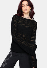 Woman wearing a black distressed jumper with long sleeves and back denim jeans on a white background