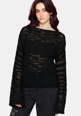 Woman wearing a black distressed jumper with long sleeves and back denim jeans on a white background