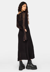 A woman modeling a black long-sleeve knit cardigan with sheer sleeves, shown from the back against a light gray studio background.