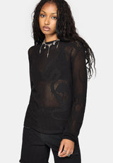 A woman modeling a black long-sleeve knit top with a sheer, openwork pattern and a decorative silver collar detail, paired with black pants against a light gray studio background.