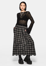 Woman wearing a black and gray checkered skirt with lace details on a white background