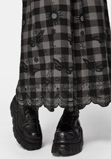 Woman wearing a black and gray checkered skirt with lace details on a white background