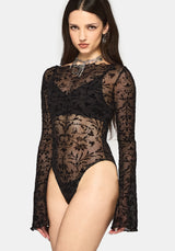 Model wearing a black mesh bodysuit on a white background