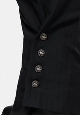 Close-up of black balloon trousers with four decorative metallic buttons on a light gray background.
