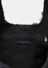 Close-up of a black bag with a brand logo on a white background