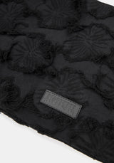 Close up of brand logo on a black textured shoulder bag