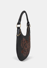 Small black handbag with intricate brown embroidery on a white background