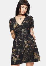 Woman wearing a black floral dress with a belt on a white background