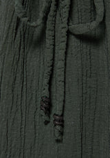 Close-up of a dark olive green crinkled fabric with matching drawstrings and black twisted cord ends.