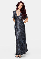 Woman wearing a black maxi satin snake printed dress on a white background