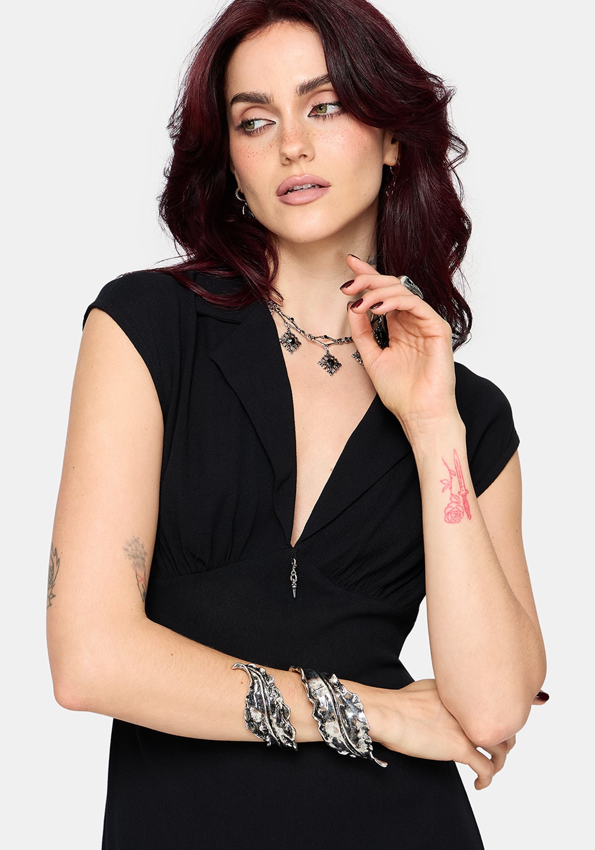 Woman wearing a black dress with silver jewelry on a white background