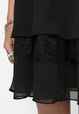 Black lace-trimmed dress on a white background