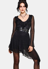 Woman wearing a black dress with ruffled details on a white background