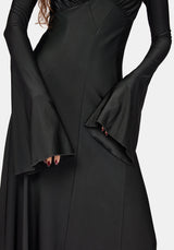 A close-up of a black long-sleeve midaxi dress with dramatic flared bell sleeves and structured seams, shown on a model against a light gray background.
