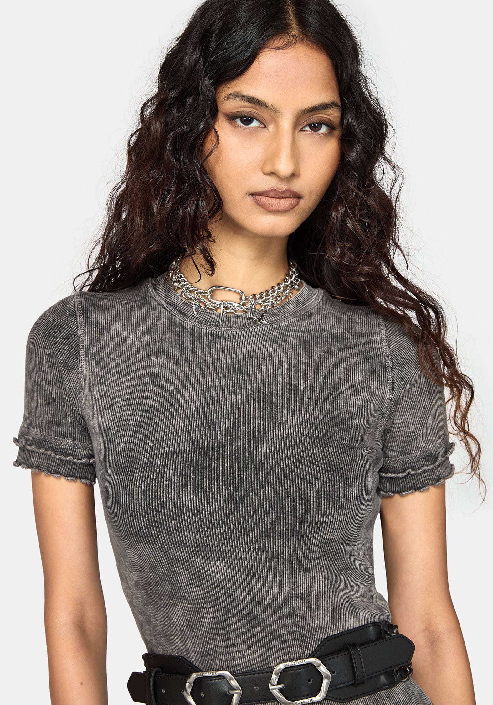 A woman wearing a short-sleeve gray ribbed midi dress with a washed, distressed finish, paired with a black belt, against a light gray studio background.