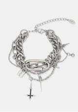 A layered silver-tone chain bracelet featuring chunky interlocking links, delicate chain straps, dangling spikes, a small padlock charm, and a cross charm, displayed on a light gray background.