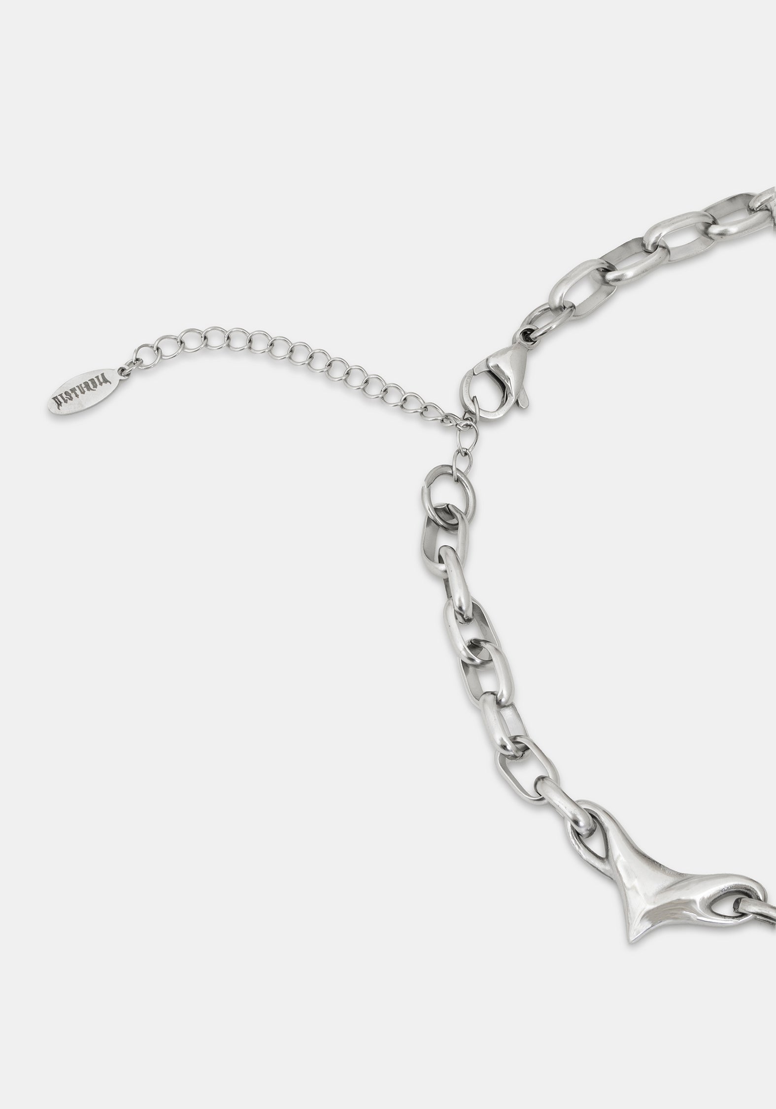 Silver chain bracelet detail showing the lobster clasp, extender chain with a tag, and a polished arrow-shaped charm on a light gray background.
