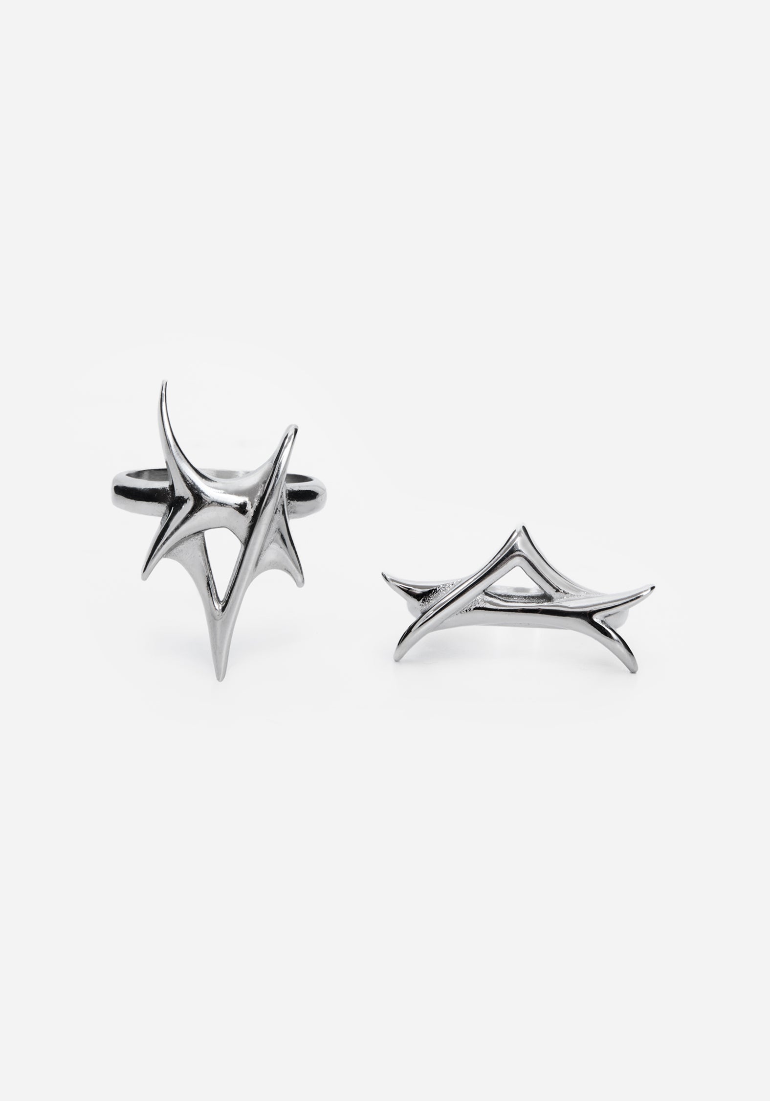 Close up two silver rings with a spike design against a white studio backdrop