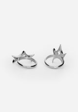 A pair of silver-toned metal rings with a stylized, spike design displayed on a clean white background.