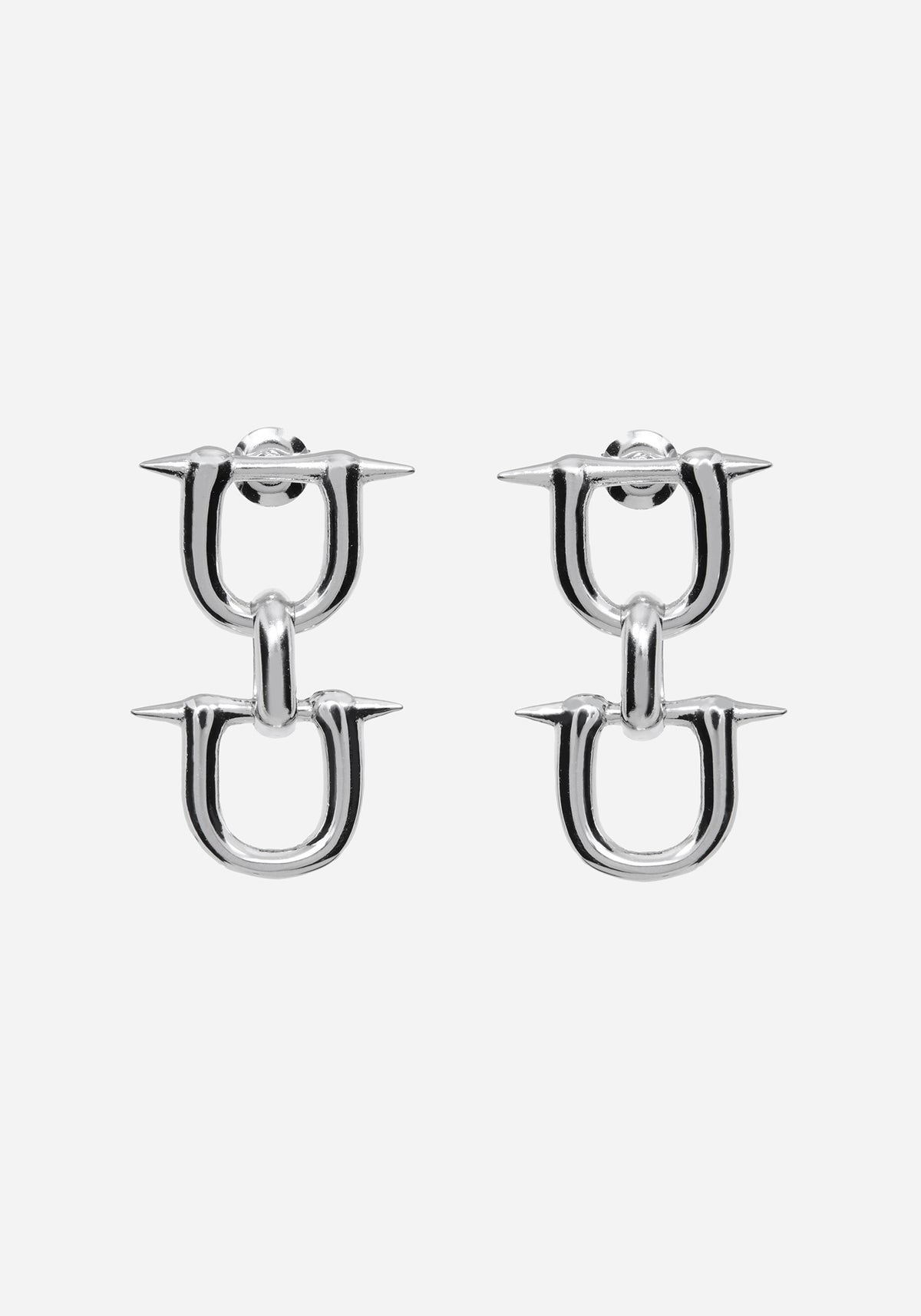 A pair of silver-toned U-shaped hoop earrings with sharp spike details on the front, shown against a plain light gray background.