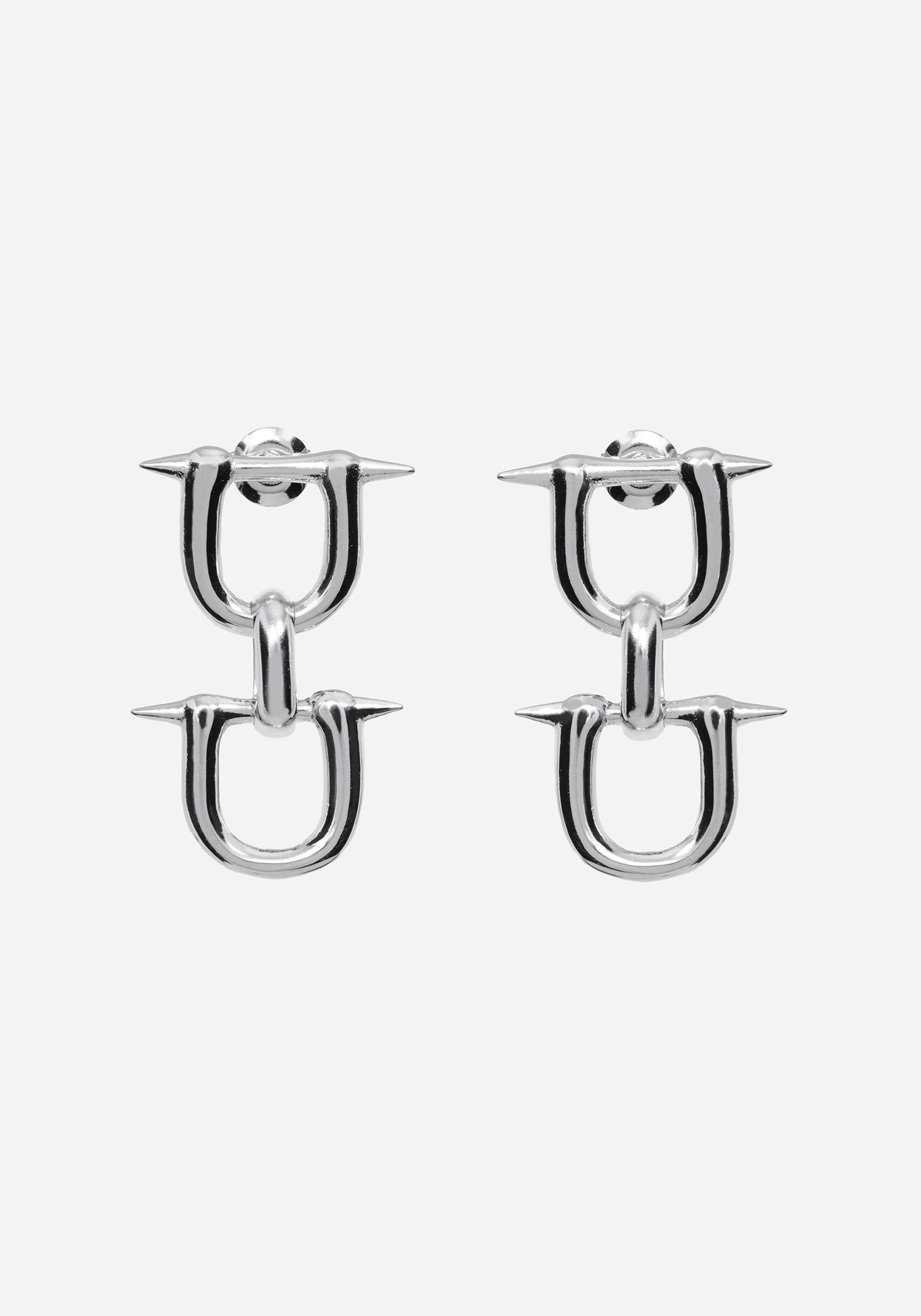 A pair of silver-toned U-shaped hoop earrings with sharp spike details on the front, shown against a plain light gray background.
