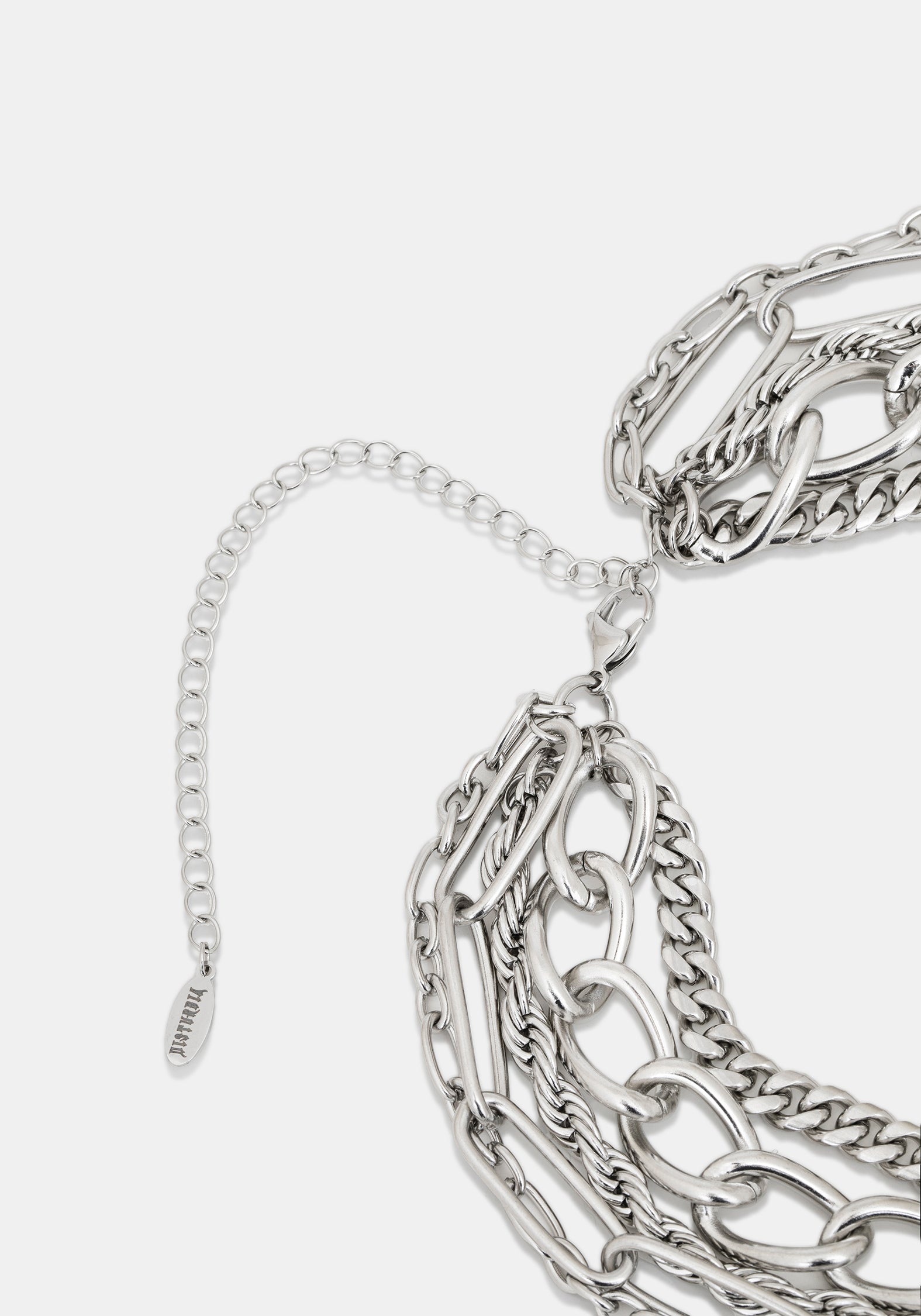 Close-up of a silver-toned chunky chain necklace with layered links and an adjustable extender chain on a light gray background.