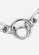 A close-up of a polished silver-toned metal chain with interlocking circular and elongated links on a plain light gray background.