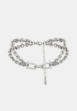 A close-up of a chunky silver double chain choker necklace with extender clasp 