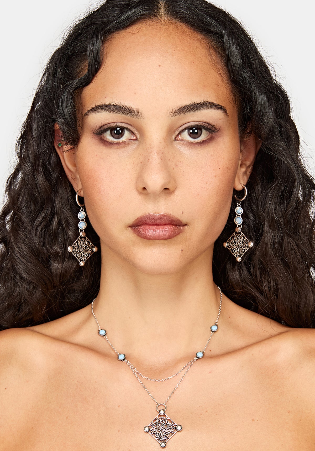 Matching jewelry set, including a silver-toned double-strand necklace with light blue beads and a matching geometric pendant, along with matching drop earrings.