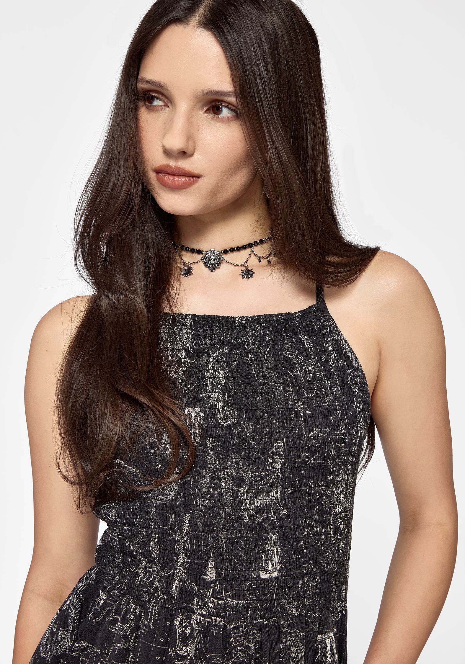 Woman wearing a black printed playsuit with a white background