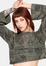 Woman wearing a patterned green jumper and black pants against a plain background