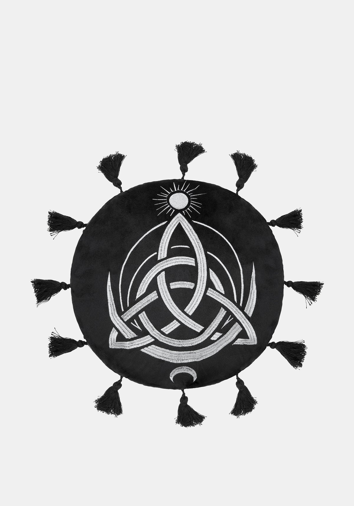 A circular black cushion with a white Celtic knot triquetra design, a small sun motif at the top, and tassels extending from the outer edge, shown on a light gray background.