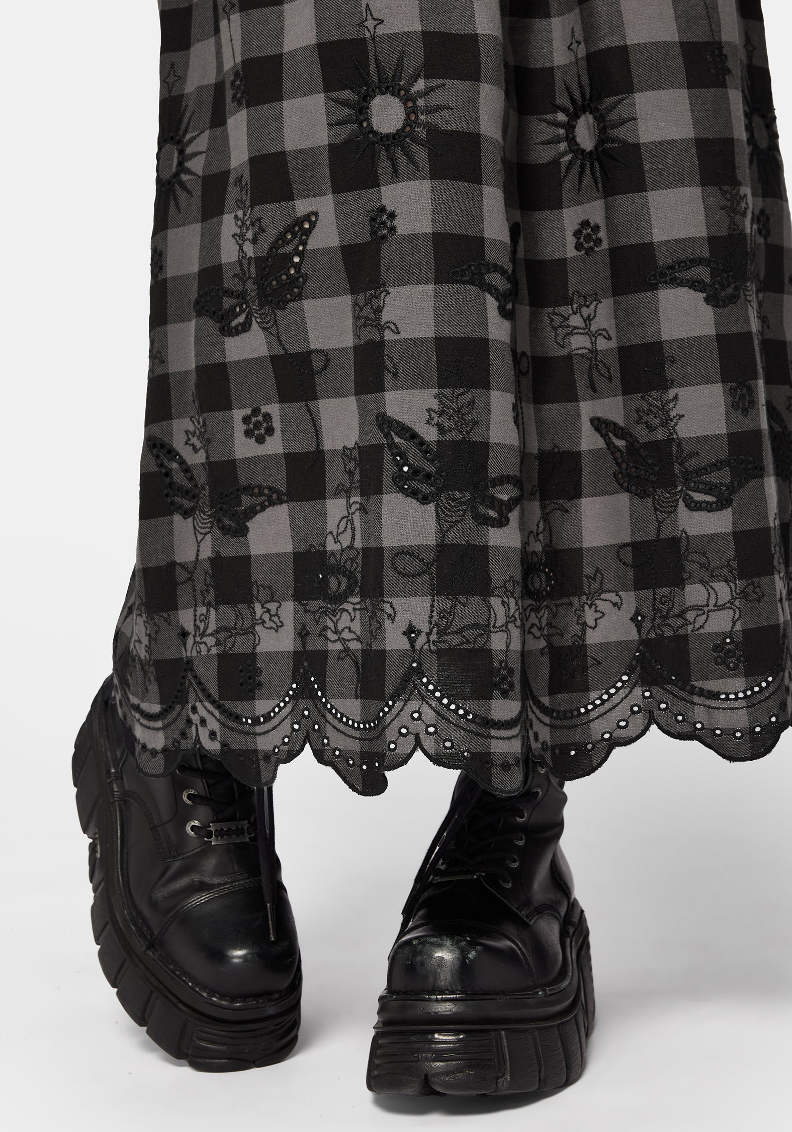 Woman wearing a black and gray checkered skirt with lace details on a white background