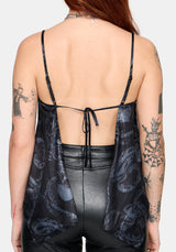 Woman wearing a black snake printed satin top with leather pants against a white background
