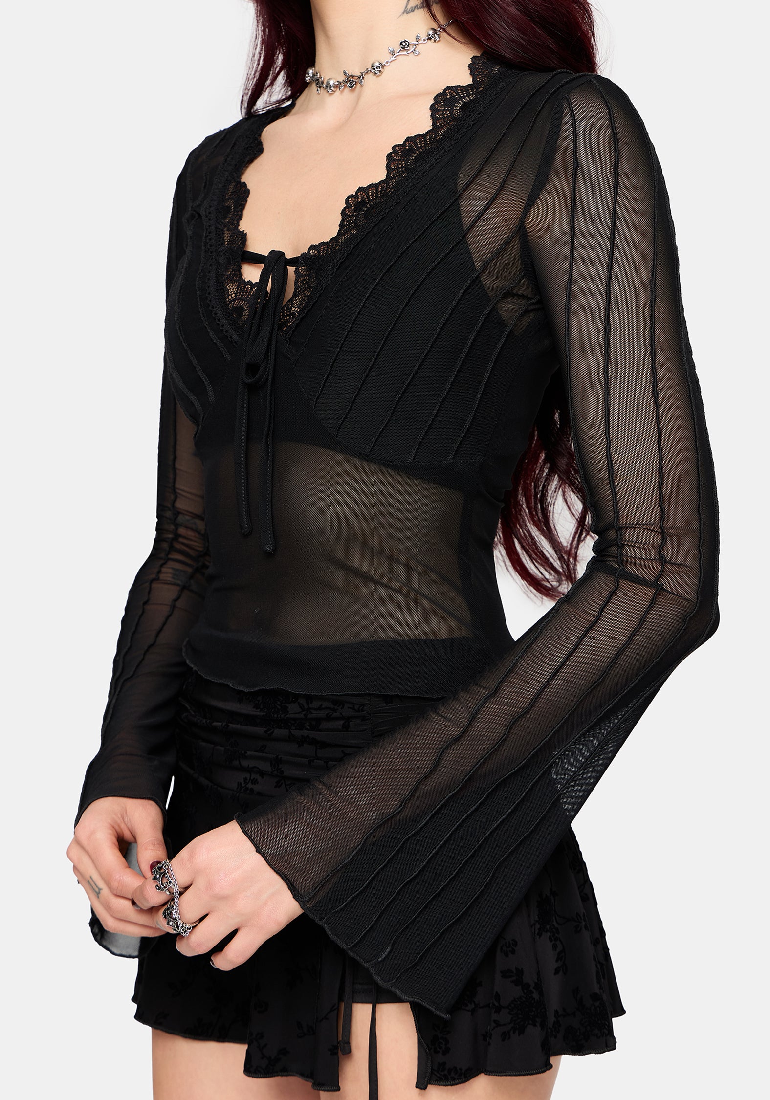 Black mesh top with sheer sleeves on a white background