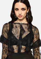 Woman wearing a black lace top against a white studio background